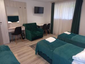 una stanza d'albergo con due letti e una sedia di Komfortowe pokoje przy Szymonowica w Krakowie a Cracovia
