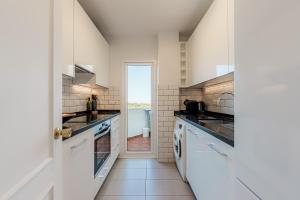 una cocina con electrodomésticos blancos y un pasillo con ventana en Secret View Calahonda, en Cabopino