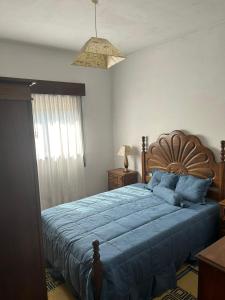 een slaapkamer met een groot bed met een blauwe deken bij Casa Encanto do Douro in Várzea do Douro