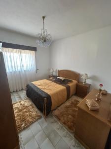 een slaapkamer met een bed, een tafel en een kroonluchter bij Casa Encanto do Douro in Várzea do Douro