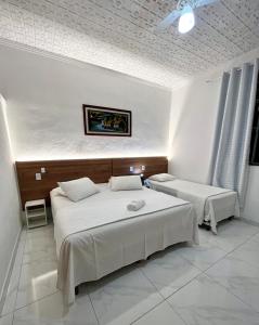 a bedroom with two beds in a room at Pousada e Chalés Arco-Íris in Lima Duarte