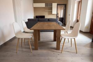 ein Esszimmer mit einem Holztisch und weißen Stühlen in der Unterkunft IL CAMPANILE Apartment in Omegna + 6 Fotos