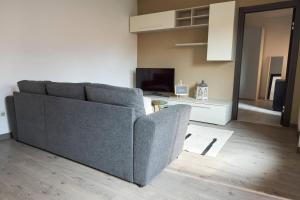 ein Wohnzimmer mit Sofa und Fernseher in der Unterkunft IL CAMPANILE Apartment in Omegna