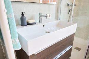 ein Badezimmer mit einem weißen Waschbecken und einem Spiegel in der Unterkunft IL CAMPANILE Apartment in Omegna