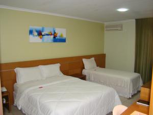 a hotel room with two beds with white sheets at Hotel Elite 1 in Nossa Senhora dos Milagres +5 photos
