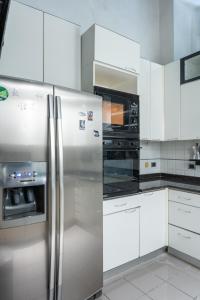 Una cocina con refrigerador de acero inoxidable y microondas. en Suites Rome, en Roma