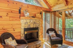 a living room with a fireplace in a log cabin at Charming 2BR Cabin with Hot Tub & Mountain Views in Sevierville