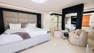 a bedroom with a large white bed and two chairs at Boeketlong Lodge in Jane Furse +74 photos