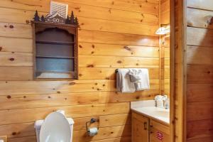a wooden bathroom with a toilet and a sink at Charming 2BR Cabin with Hot Tub & Mountain Views in Sevierville +18 photos