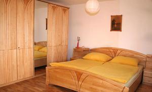 ワイレックにあるBauernhof Kronsteinerのベッドルーム1室(大型木製ベッド1台、黄色いシーツ付)
