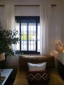 ein Wohnzimmer mit einer Couch und zwei Kissen darauf in der Unterkunft La Casita de Wilson in Los Marines + 27 Fotos