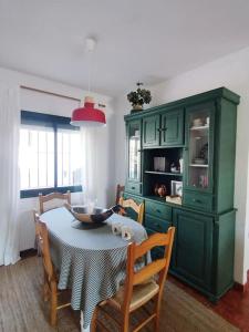 a dining room with a table and a green cabinet at La Casita de Wilson in Los Marines