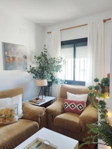 ein Wohnzimmer mit zwei Sofas und einem Tisch in der Unterkunft La Casita de Wilson in Los Marines