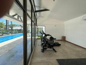 a gym with a treadmill and a swimming pool at Grettabril JACO BEACH APARTMENT in Jacó