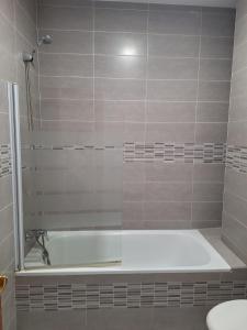 un baño con bañera y lavabo en apartamentos Centro PICASSO, en Málaga