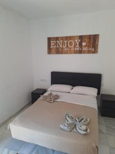 Una cama con lazos en un dormitorio. en apartamentos Centro PICASSO, en Málaga