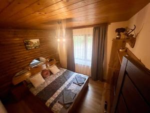 a small bedroom with a bed in a wooden house at Villa Capricorn in Tsigov Chark