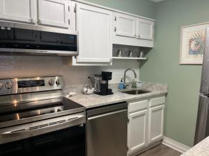 a kitchen with white cabinets and a stainless steel appliance at Cherry Grove condo just steps from the ocean in Myrtle Beach
