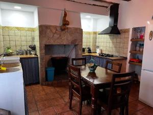 a kitchen with a wooden table and a fireplace at La Cariochaca in Casas Ibáñez