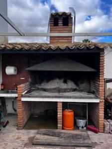 an outdoor brick oven with an orange object in it at La Cariochaca in Casas Ibáñez
