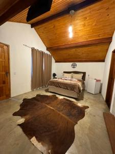 a bedroom with a bed and a wooden ceiling at Pousada Fazenda coronel in Camanducaia