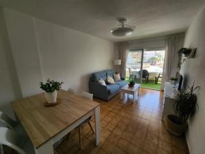 ein Wohnzimmer mit einem blauen Sofa und einem Tisch in der Unterkunft Seaview Terrace, Beachfront Bliss & Towncenter - Terraza con vistas al mar, a pie de playa y céntrico in La Herradura