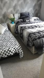 a bedroom with two beds with black and white sheets at Unique 2 bed lodge lyons Robinhood in Rhyl +14 photos