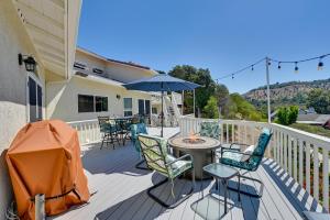 a deck with a table and chairs and an umbrella at San Marcos Getaway with Deck and Lake Views! in San Marcos