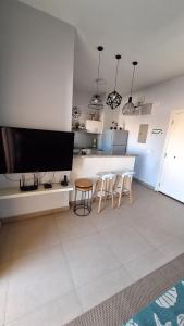 a living room with a tv and a table and chairs at Waterside Apartments, El Gouna - 1Bd Ground Floor in Hurghada +30 photos