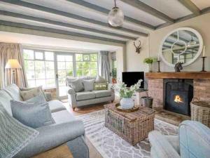 un soggiorno con divano e camino di Charming retreat with hot tub and lake terrace a Hilderstone