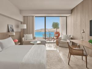 a hotel room with a bed and a view of the ocean at The Bodrum EDITION in Yalıkavak