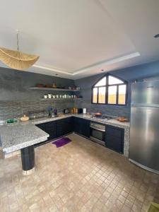 Una cocina grande con refrigerador de acero inoxidable. en Refuge Vert à 15 min de Marrakech, en Marrakech