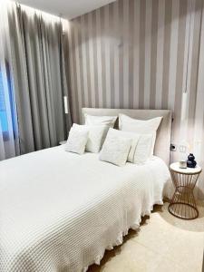 a bedroom with a white bed with white pillows at Bali Bay Luxury Apartment in Balíon