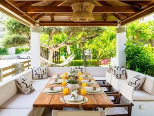 an outdoor dining room with a wooden table and chairs at Bali Bay Luxury Apartment in Balíon
