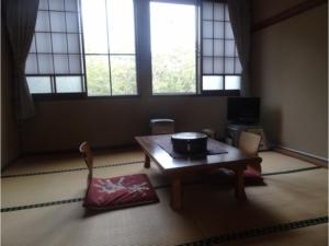 a living room with a table and two windows at Shinyu Onsen Kurikomaso - Vacation STAY 45507v in Kurihara