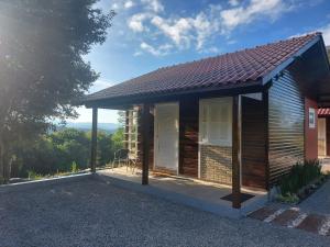 a small wooden house with a porch at Chale Vale Carahá Lavanda in Gramado