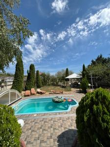 a swimming pool in a yard with a patio at Sanpic in Sanzhiyka