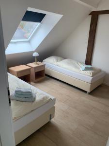 a attic bedroom with two beds and a table at Ferienwohnung, 3 Zimmer, 100 qm, Betten trennbar 2. Stock in Ilbenstadt
