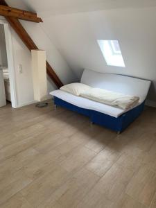 a bed in a room with a wooden floor at Ferienwohnung, 3 Zimmer, 100 qm, Betten trennbar 2. Stock in Ilbenstadt