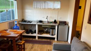 a small kitchen with a table and a counter top at Casa com Conforto, Tranquilidade em Meio à Natureza in Gonçalves