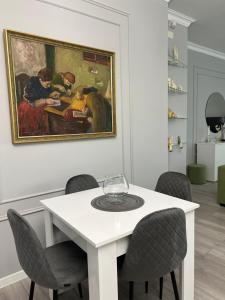 a dining room with a white table and a painting at VILLAge GOGHT in Goghtʼ