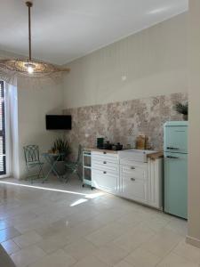 een keuken met witte kasten en een blauwe koelkast bij Casa Nassiriya in Trani