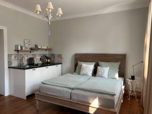 a bedroom with a bed and a kitchen in it at Landhaus hinter`m See Ferienwohnung Zur Schneiderei Kachelofen Schlittenbett Smart-TV in Hintersee