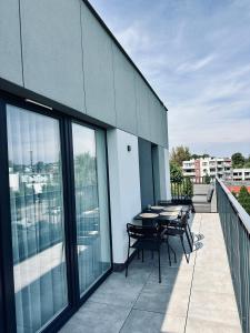 Un balcón con mesas y sillas en un edificio. en Apartament Morski Chill, en Jastrzębia Góra