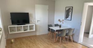 a dining room with a table with chairs and a television at Ferienwohnung Stadtnah im grünen in Ravensburg