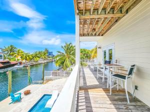 ein Balkon mit Tisch und Stühlen und Blick aufs Wasser in der Unterkunft Manatee Watch in Big Pine Key
