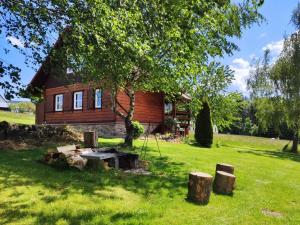 a log cabin with a picnic table in the yard at Domek Klimkówka in Klimkówka