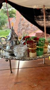 a tray with a tea kettle and cups on a table at Gite Marbie maison rurale, une expérience naturelle unique, au coeur du moyen atlas, Maroc in Kasba Tibouda