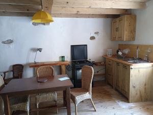 a kitchen with a table and chairs and a television at maison dans village rural in Saint-Louis-et-Parahou