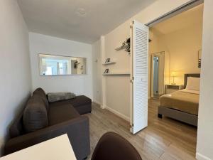 una sala de estar con un sofá y una cama en Villas at Auxilio Mutuo 103, en San Juan